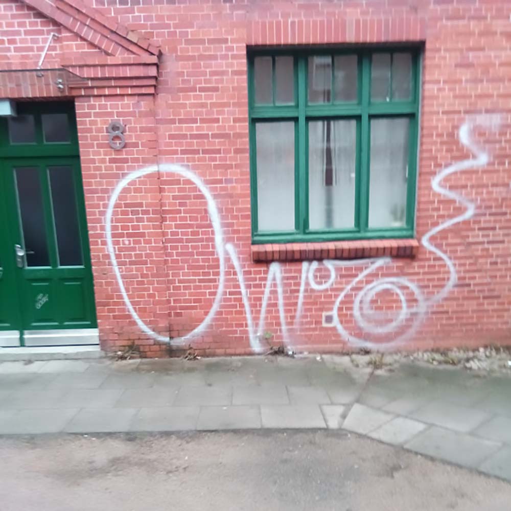Ein Graffiti vor der Entfernung - die Fassade ungereinigt.